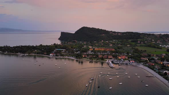 Idyllic Salo city promenade and riviera on Garda lake after sunset Italy. Aerial view of colorful co