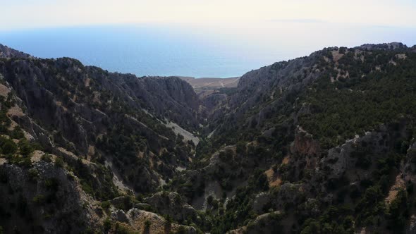 Aerial view of Gorge Canyon at Crete, Greece. Flying above Mountains near Sea in National park