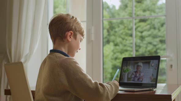 School Child Studying Math with Senior Teacher Online Using Laptop for Distance Learning at Home