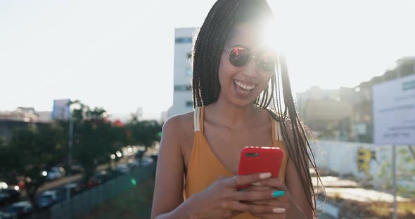Mixed race girl using smartphone outdoor with city in background