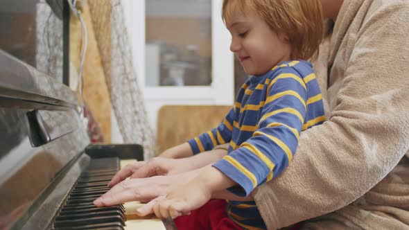 Little Happy 2 Year Old Kid Learning to Play Piano at Home with Grandma