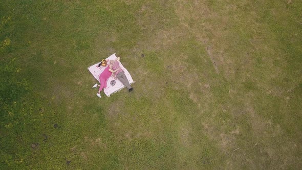 Family Weekend Picnic in Park. Aerial View. Senior Old Couple Lie on Blanket on Green Grass Meadow