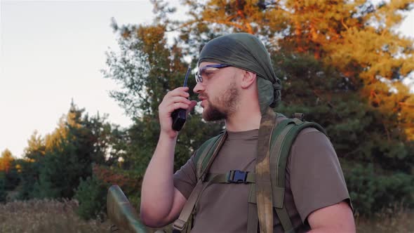 Man in Camouflage Speaking on the Radio