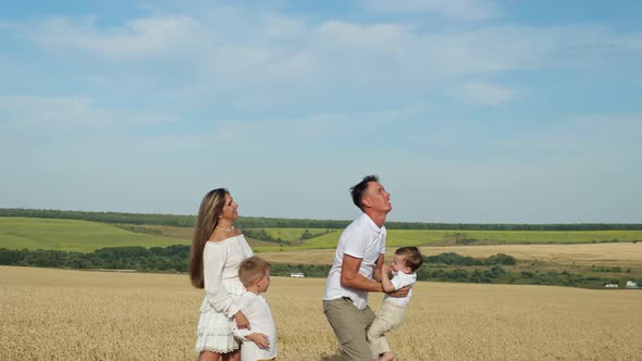 Young Father Tosses Son and Mother with Elder Boy Looks