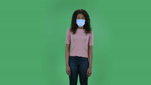 Portrait of Beautiful African American Young Woman in Medical Protective Face Mask Looking at Camera