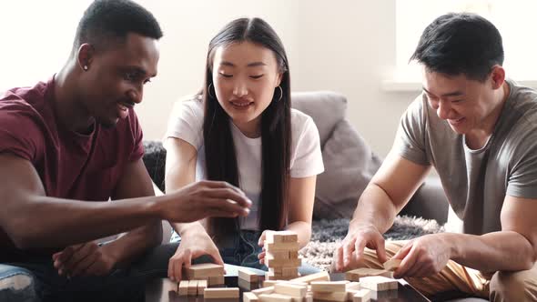 Young Multi Ethnic People Playing Jenga Game Indoors