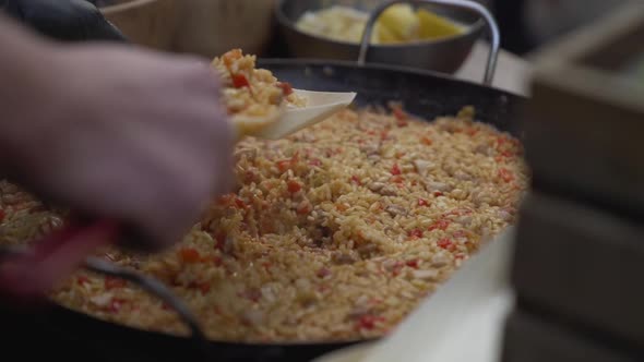 Cooking Paella, Spanish Cuisine, Cook Prepares Paella and Puts It in Eco-friendly Paper Disposable