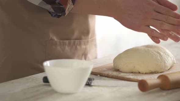 Man Chef Kneads The Dough With His Hands In The Kitchen Percarne