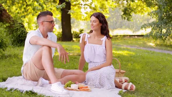 Happy Couple Having Picnic at Summer Park