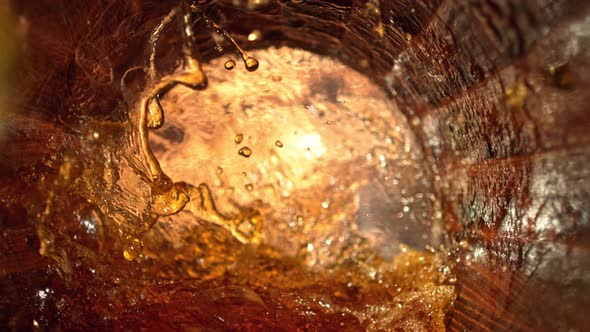 Super Slow Motion Shot of Splashing Whiskey in Old Oak Barrel at 1000Fps