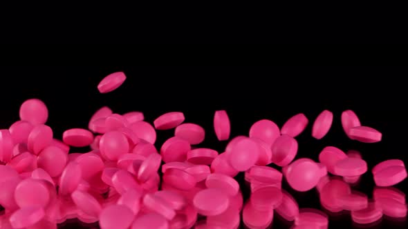 Super Slow Motion Shot of Falling Pink Pills on Black Background at 1000Fps.