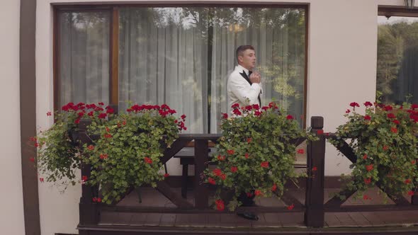 Handsome Groom Man Wearing White Jacket Stand on Balcony at Home Gets Ready Before Date or Meeting