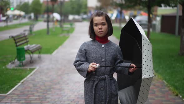 Portrait of Confident Relaxed Little Person Dancing with Umbrella Singing on Rainy Overcast Day in