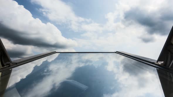 Time lapse of clouds reflected in roof window glass, tilted up against the sky, family house, home,