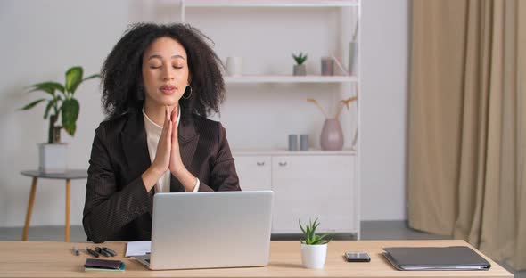 Afro American Curlyhaired Business Woman Sitting in Office Folding Her Palms in Supplication Asks