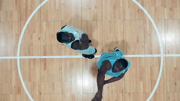 African American Players are Fighting for a Basketball in the Gym in a Top View