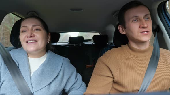 Couple Listens to Music Sings and Dances Driving Car