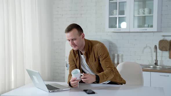 Male working with laptop at the table at home