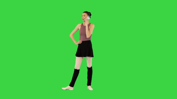 Young Ballerina Talks on Mobile Phone Making a Little Warmup on a Green Screen Chroma Key