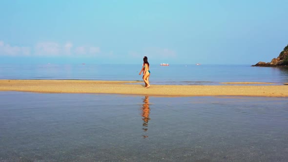 Girls look beautiful on idyllic resort beach break by blue water with white sandy background of Thai