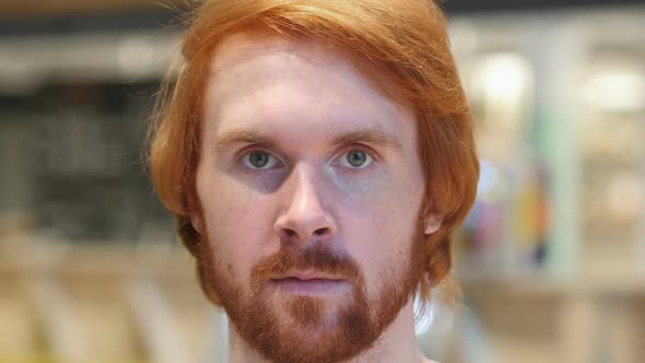 Face Close Up of Serious Redhead Beard Man Looking at Camera