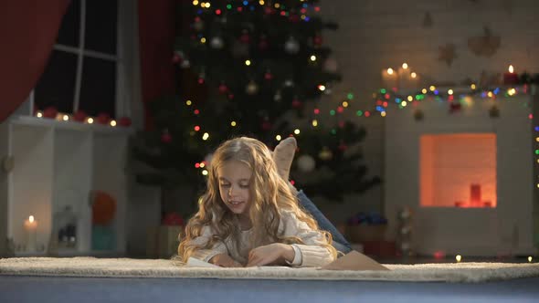 Cute Girl Putting Letter for Santa Into Envelope, Childish Belief in X-Mas Magic