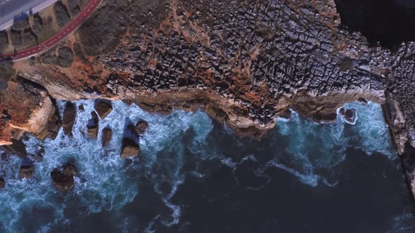 Sea waving near cliff with jogging track