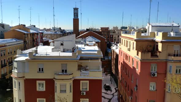 Roof top on a clear and sunny day in Madrid. There is snow on top of the buildings and drops can be