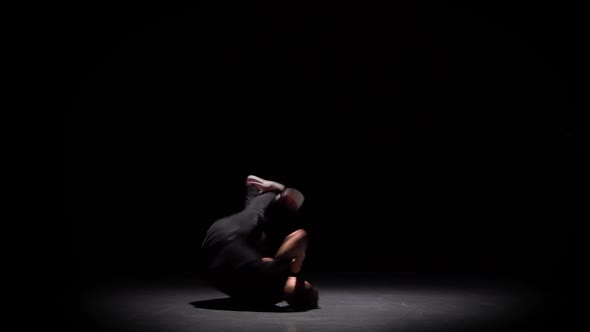 Silhouette of a Talented Young Break Dancer. Hip Hop Street Dance on a Stage in Back of the