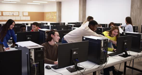 Young multiracial students using computer inside classroom at university