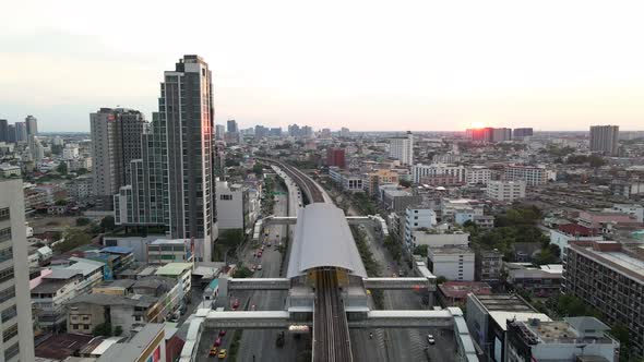 Aerial view of train station and tracks,ing backwards to reveal Bangkok cityscape