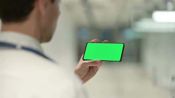 Male Doctor Watching Something on Smartphone with Chroma Screen