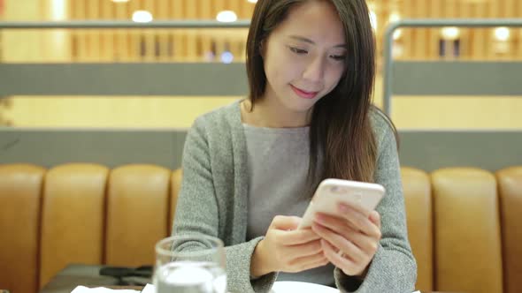 Woman working on mobile phone in restaurant