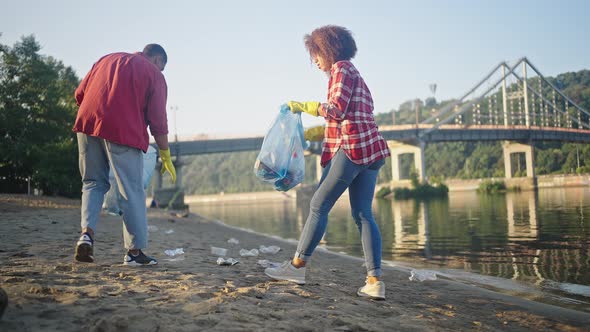 African American Volunteers Clean Beach From Trash Together