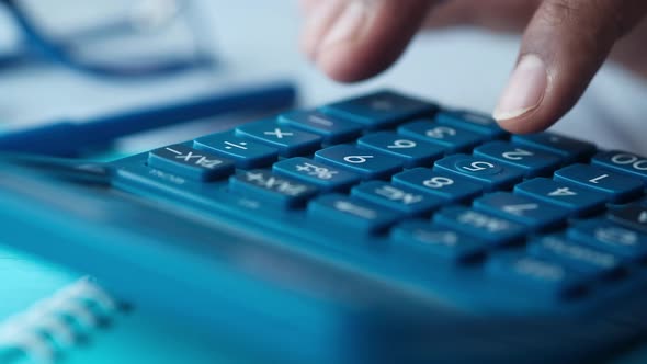 Close Up of Man Hand Using Calculator 