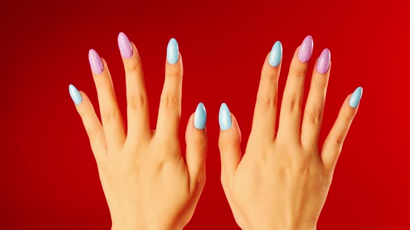 Woman's Hands with Beautiful Nails on Red Background