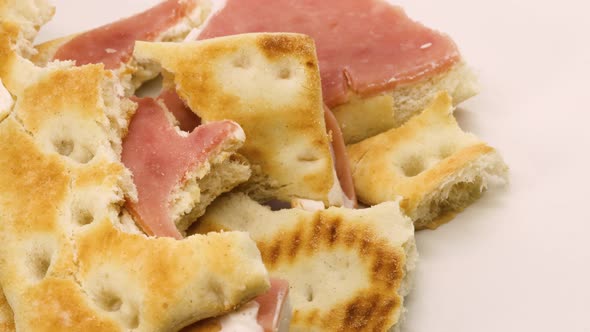 Sandwich leftovers, ham and cheese sandwich solid food waste rotating over white surface background,