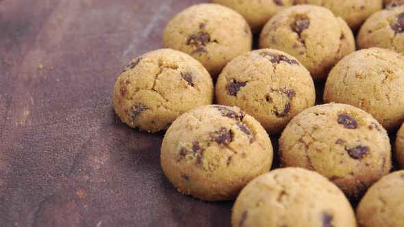 Pile of delicious chocolate chip cookies. Round small biscuits on a wooden surface. Macro