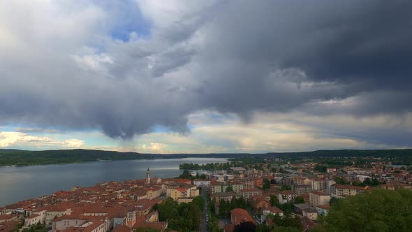 Incredible wide-angle time-lapse of dark stormying clouds over Aronacity and Maggiore lake in Italy