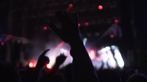 People Waving Hands in Air, Enjoying Good Music and Light Show at Concert Hall