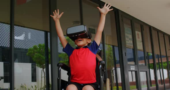 Front view of disabled African American schoolboy using virtual reality headset in school corridor 4