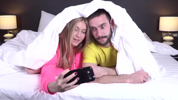 Couple on a Comfortable Bed Taking a Selfie