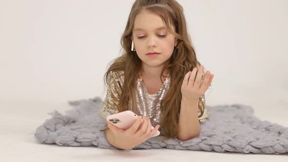 Little Girl Listens to Music with Wireless Headphones