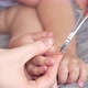 Mom carefully cuts the nails of a sleeping baby 12-15 months with nail scissors. Selective focus - VideoHive Item for Sale