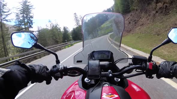 Motorcyclist Rides on Beautiful Landscape Mountain Road Near Snowy Switzerland Alps