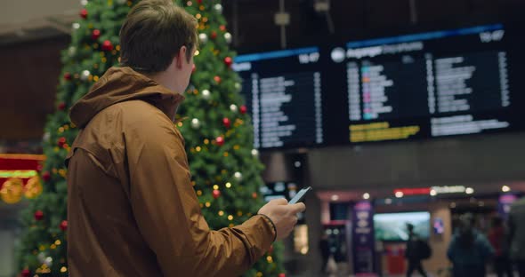 Man Look at Info Timetable Screen in Airport