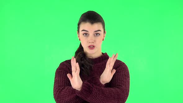 Woman Strictly Gesturing with Hands Crossed Making X Shape Meaning Denial Saying NO. Green Screen