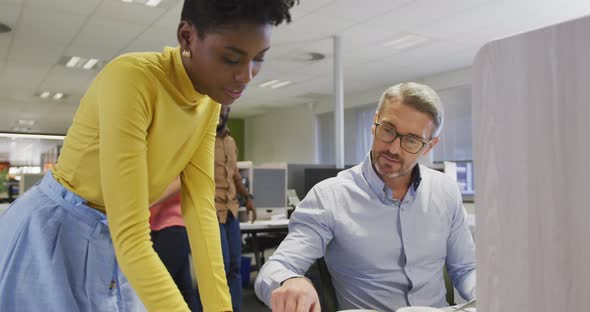 Diverse male and female business colleagues talking in office