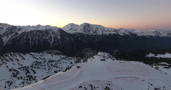 Ski resort summit on the French Alps at Chamrousse during sunrise, Aerial dolly right shot