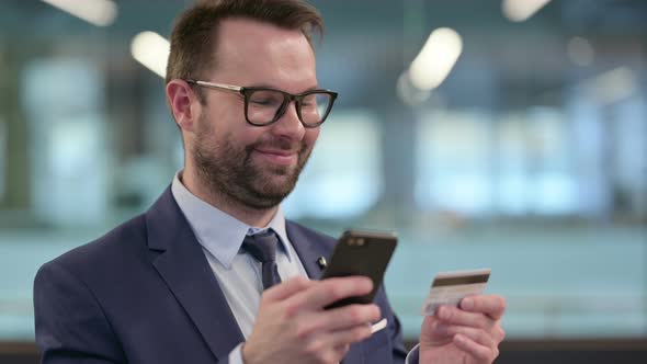 Middle Aged Businessman with Online Shopping Success on Smartphone